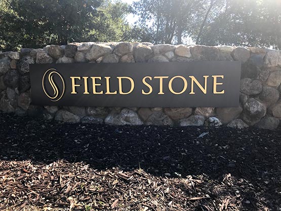 Here is a 1/4" thick powder-coated aluminum sign curved to match the rock wall behind it, then we added 1/2" brushed brass letters and logo and spaced them off the surface 1/2"