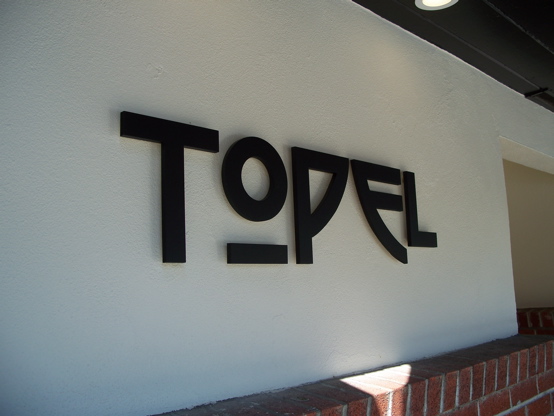 1/2" aluminum letters painted matte black and pin-mounted approx. 1/2" off stucco surface