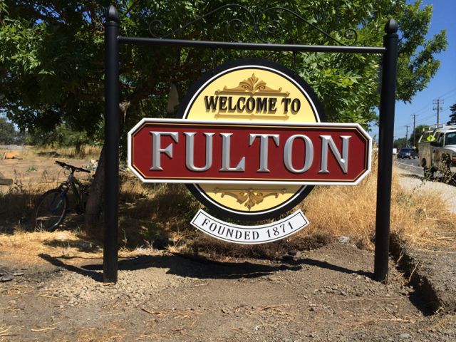 This sign identifying the Town of Fulton is 3 dimensionally carved urethane over resined MDO with palladium leaf and acrylic house paints... with custom powdercoated posts and bracket.