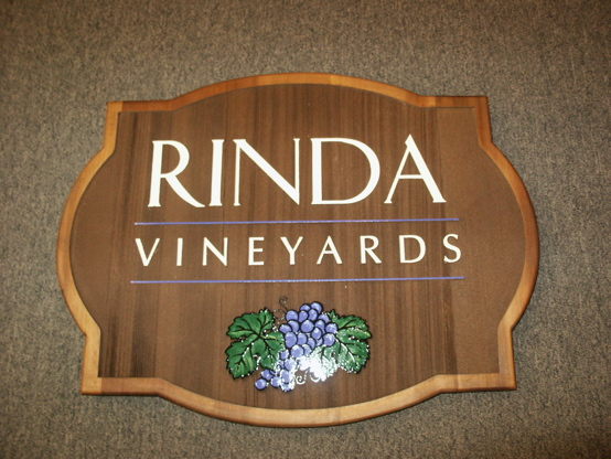 Sandblasted cedar with verticle grain 

and a light stain.  The grape graphic is design by us and hand lettered
